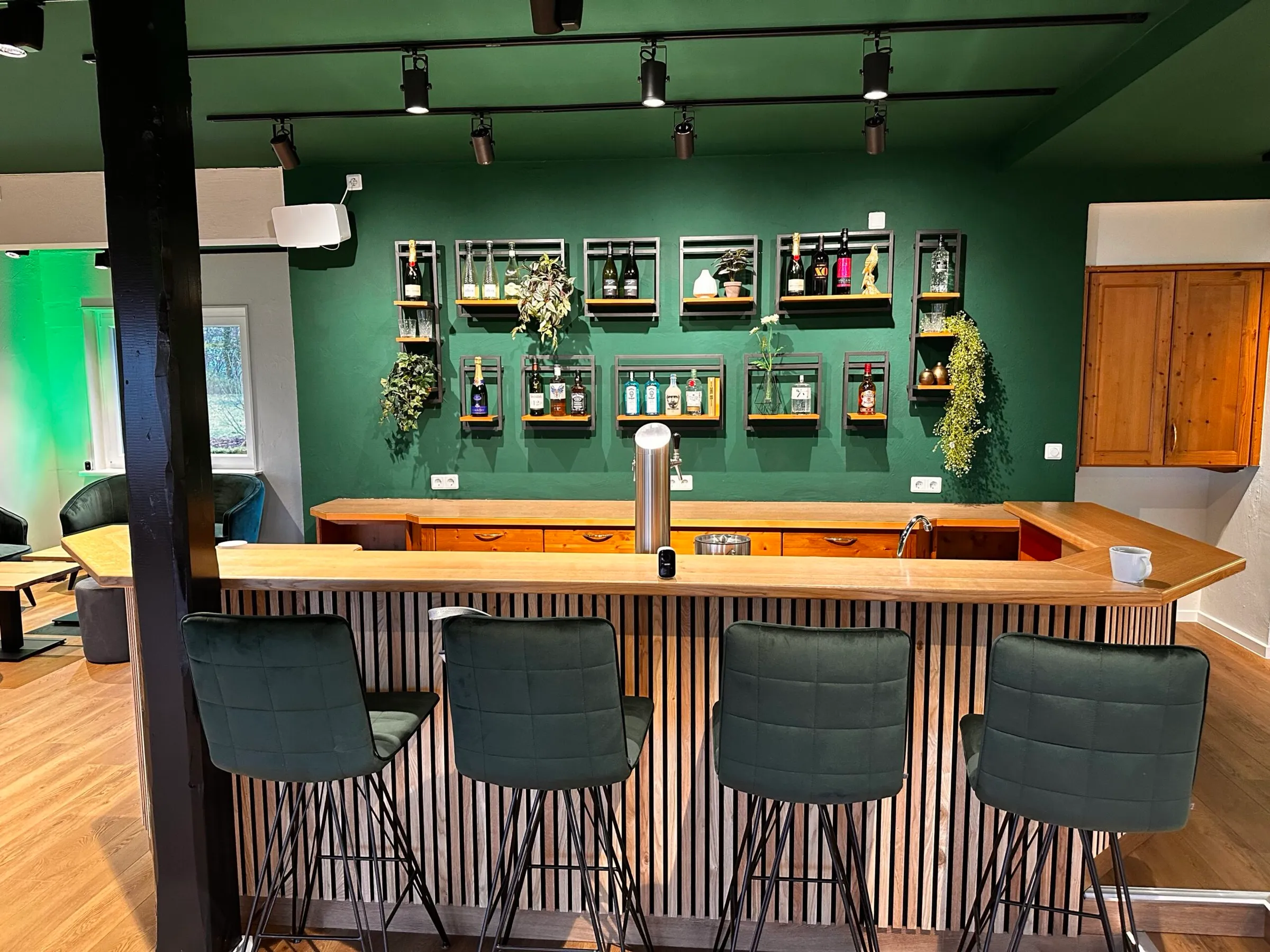Stilvolle Bar mit grüner Wand und Holztheke im Ausblick am Wieterturm